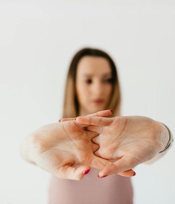 Woman performing a gentle stretching exercise in a calm, minimalist environment.